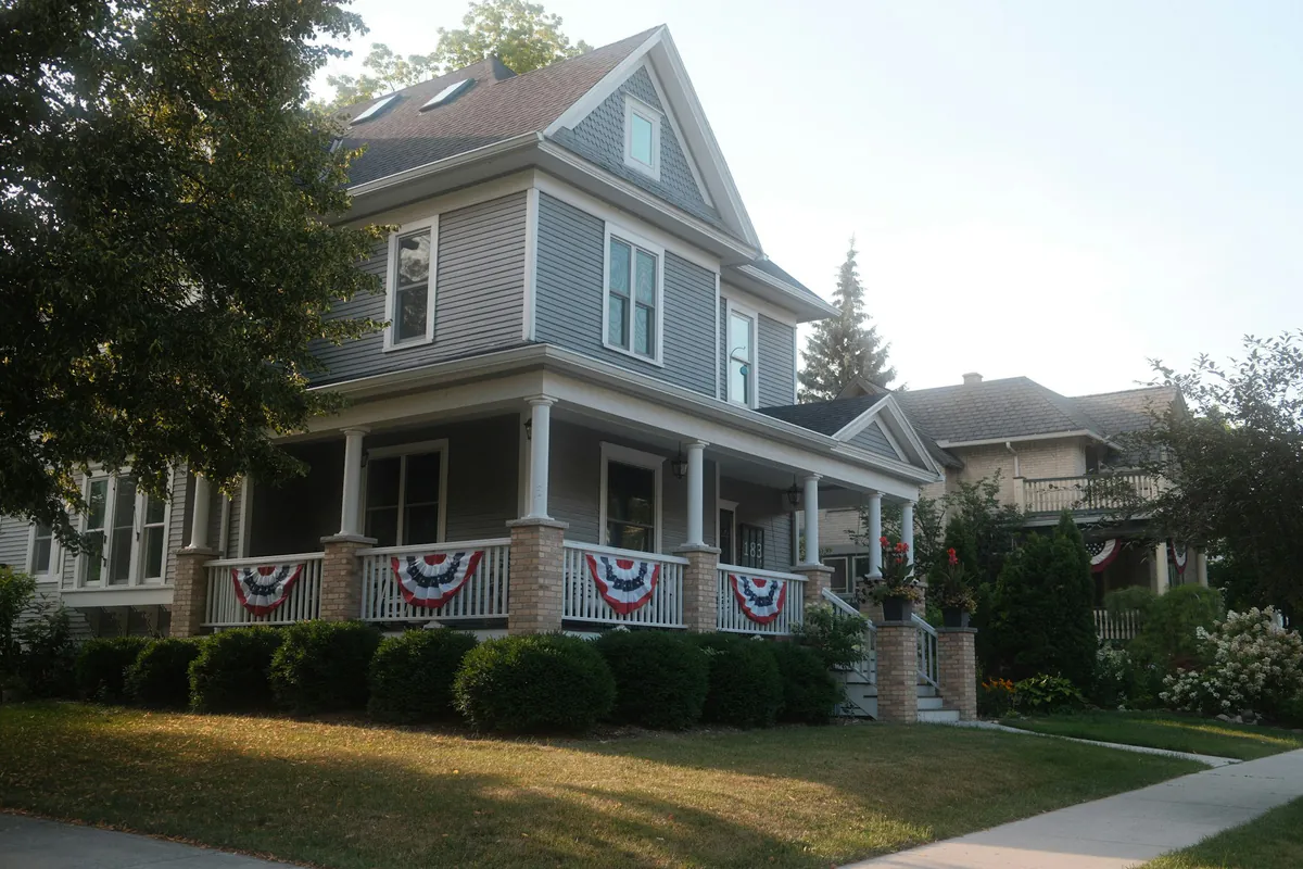 Gray two story New York home with a covered front porch