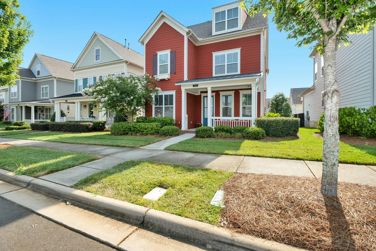 Red and gray North Carolina houses along a sidewalk lined neighborhood street