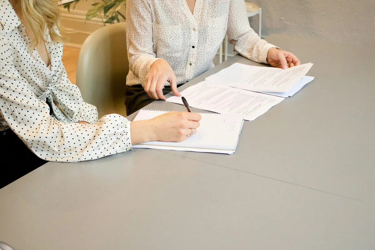 Two people reviewing legal paperwork together at a table